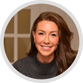 Smiling woman with long brown hair in a dark sweater, a circular headshot for a client testimonial