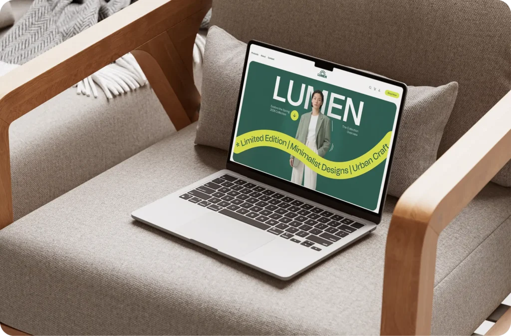 Laptop on an armchair showing the Lumen fashion website, with a Limited Edition, Minimalist Designs, Urban Craft banner