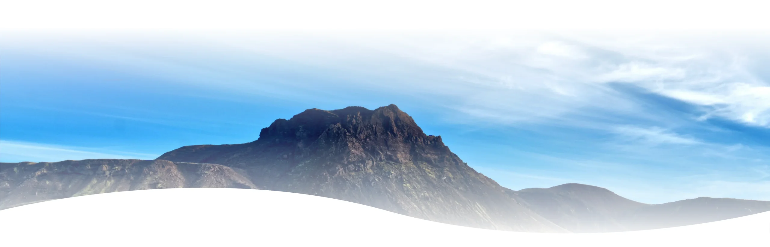 A serene landscape of a mountain range under a blue sky, with a vast expanse of white sand dunes in the foreground, inviting